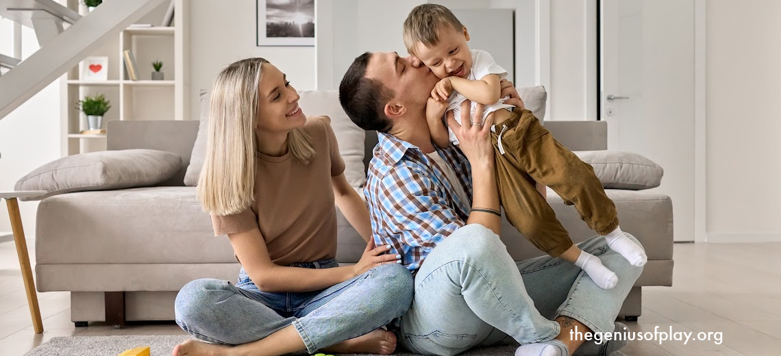 Caucasian mom and dad happily playing with their toddler son on the floor with blocks