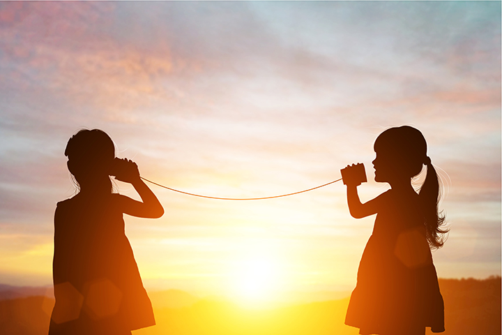 two kids communicating through a can and piece of string