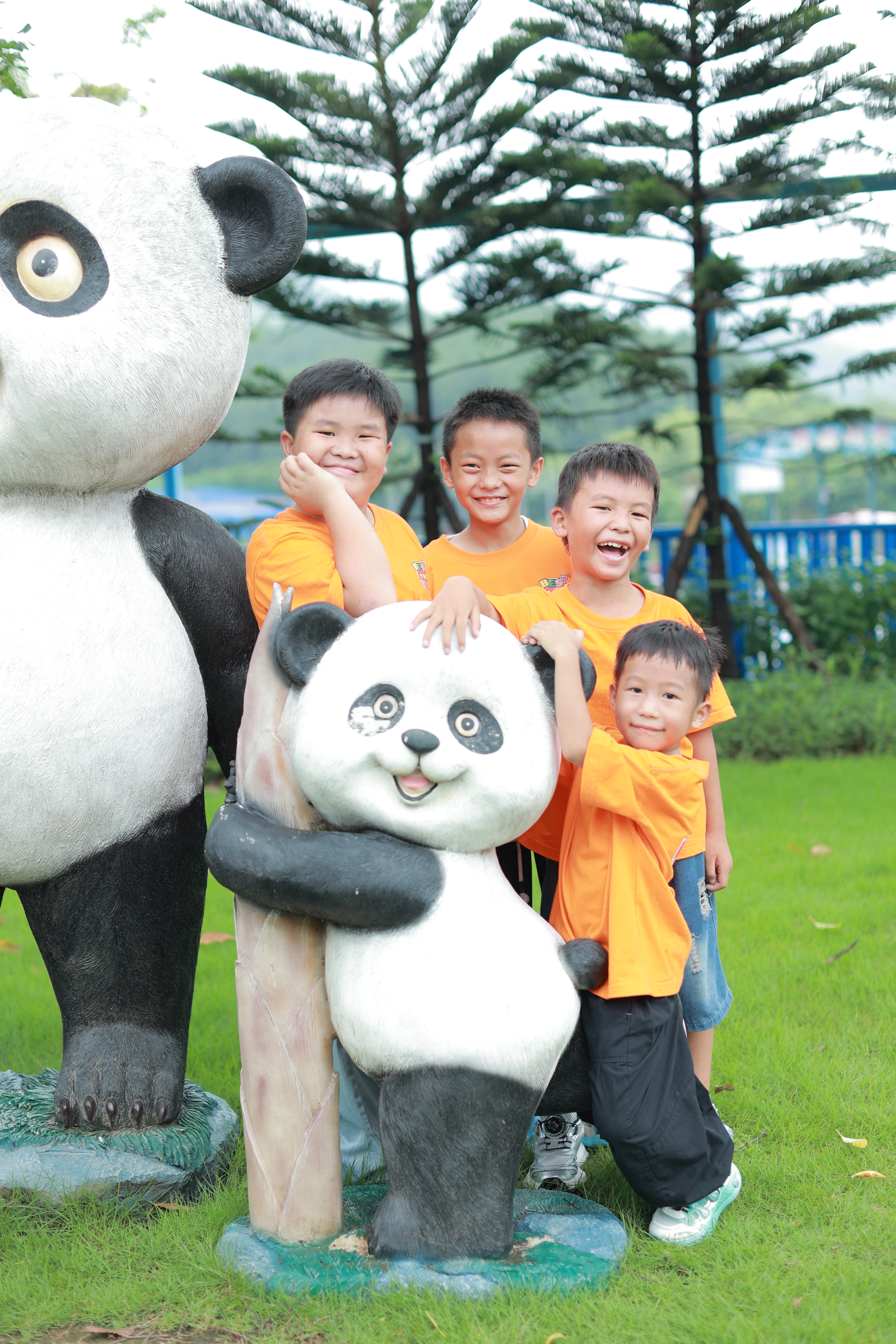 kids standing in front of panda statue